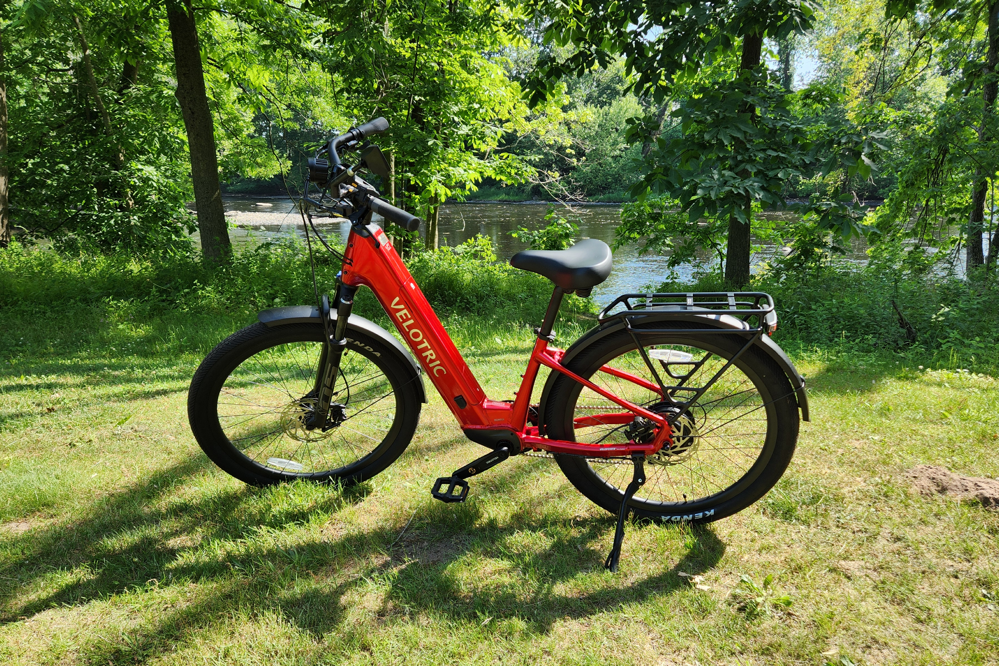 Velotric Discover 2, вид в профиль слева, припаркованный рядом с рекой Фармингтон.