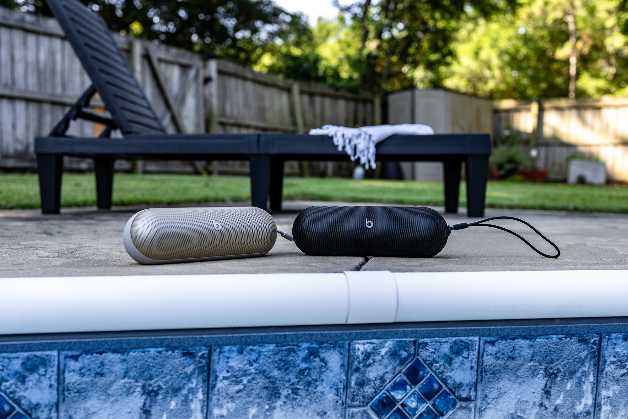 Ein Paar Beats Pill-Lautsprecher neben einem Pool