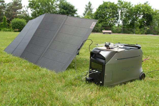 EcoFlow Delta Pro 3 power station on grass, connected to solar panels and several personal devices.