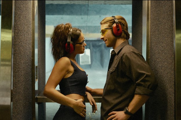 A man and a woman stand in a gun range in Hit Man.