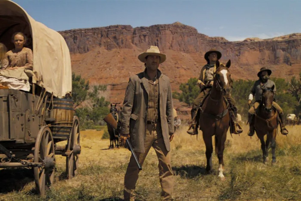 Vaqueros parados en un campo en el horizonte: una saga estadounidense.