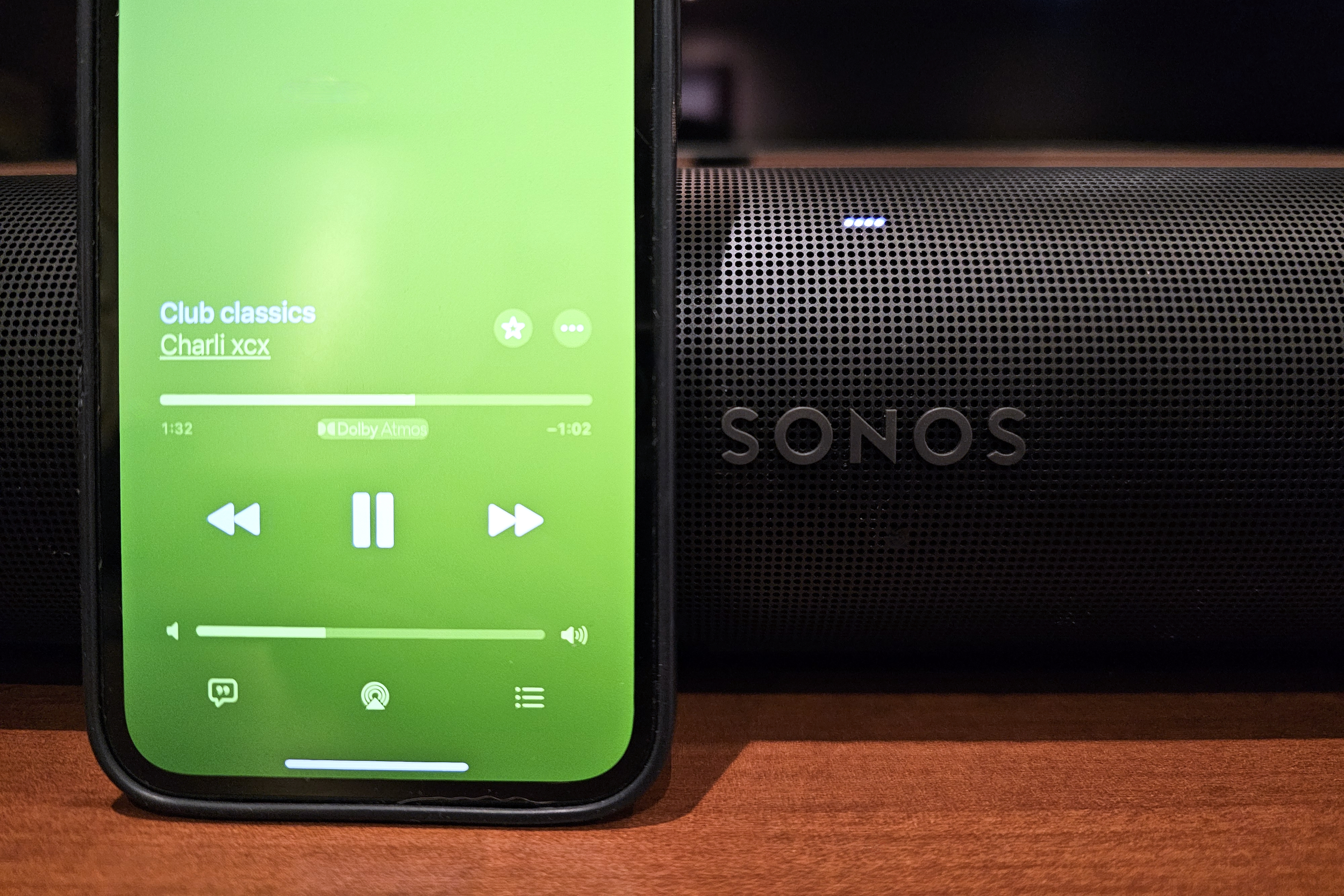 Um iPhone tocando Dolby Atmos Music da Apple Music em frente a uma barra de som Sonos Arc.