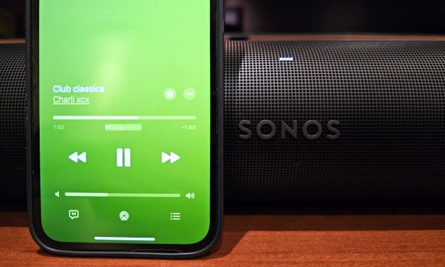 An iPhone playing Dolby Atmos Music from Apple Music sitting in front of a Sonos Arc soundbar.