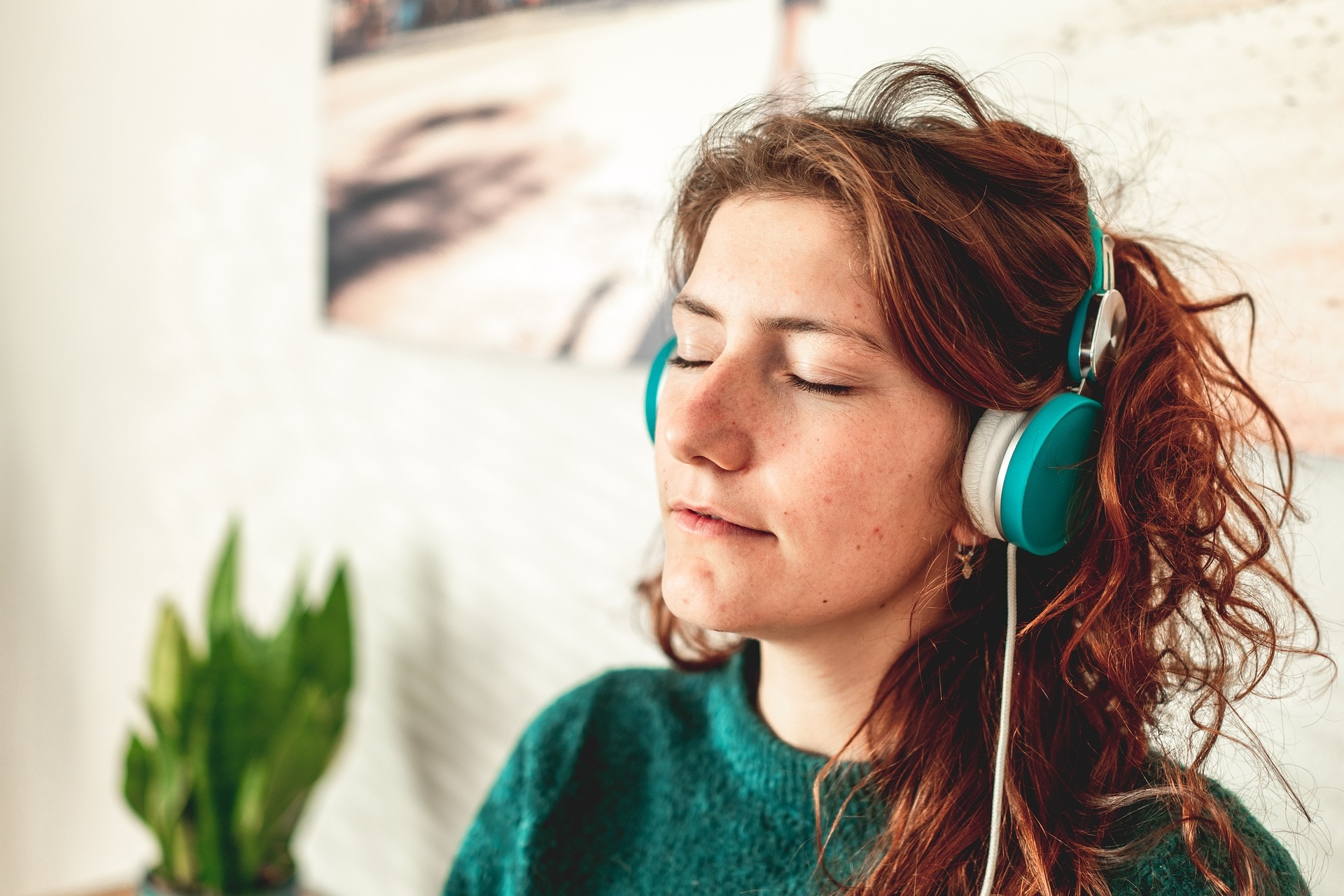 A woman wearing headphones with her eyes closed.