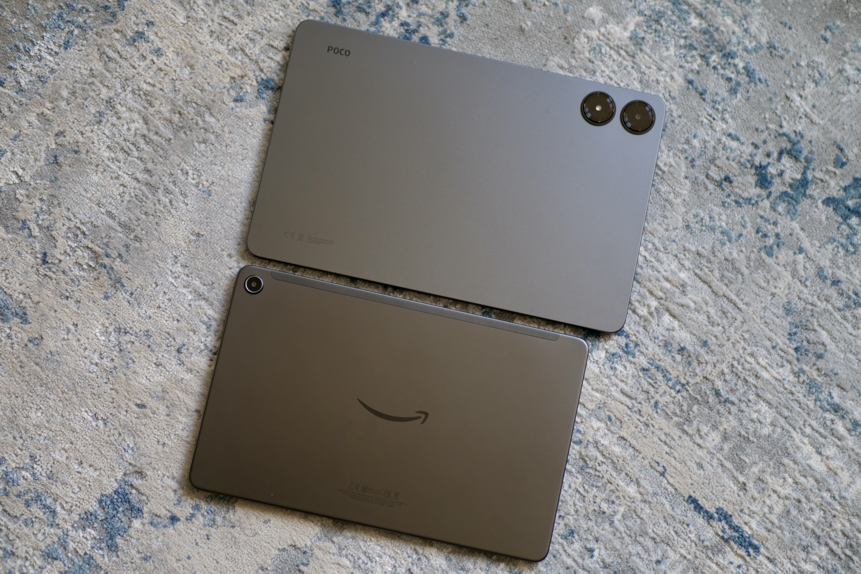The Amazon Fire Max 11 and Poco Pad together, showing the back panels.