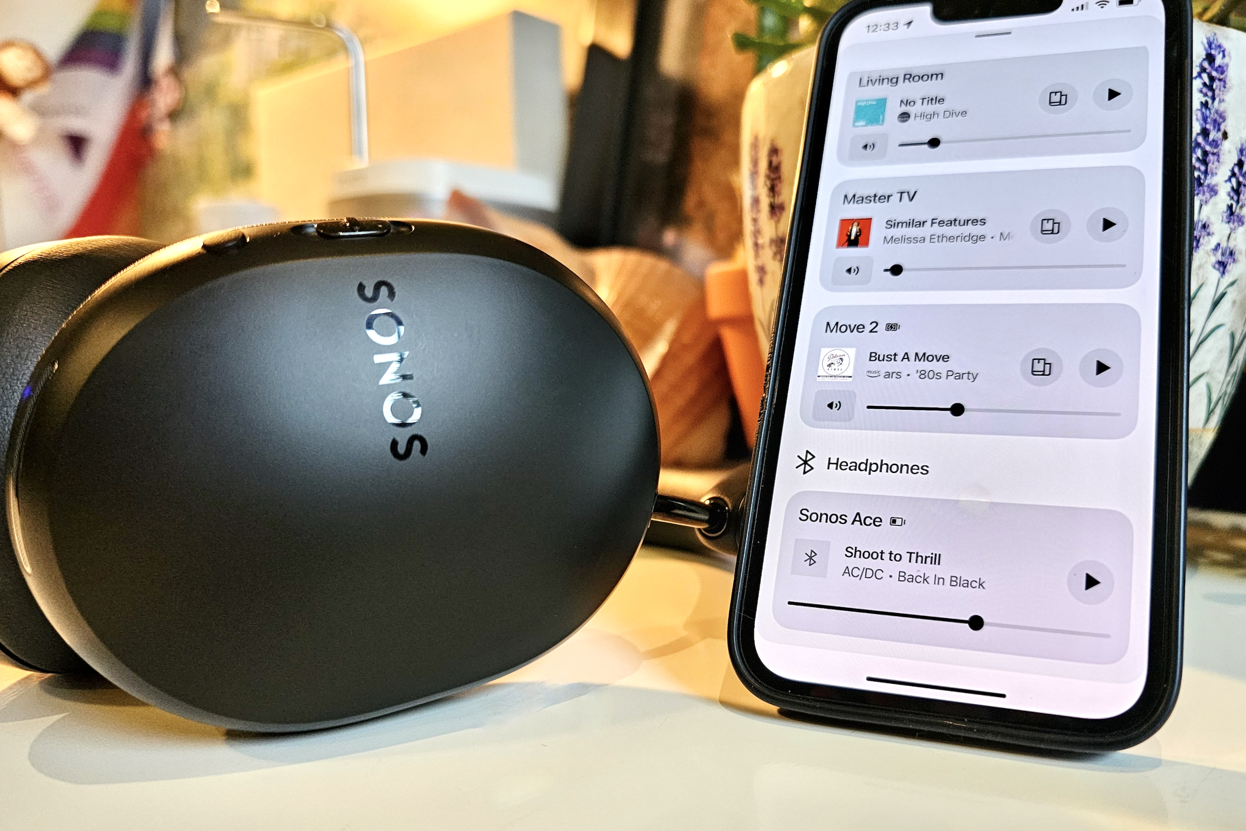 Sonos Ace junto a un iPhone 14 que muestra la aplicación Sonos.