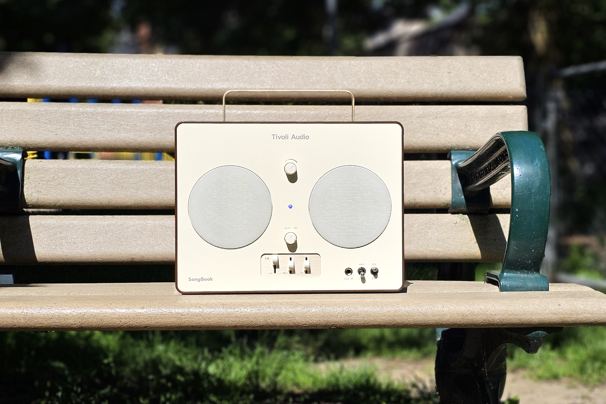 Tivoli Audio SongBook sur un banc de parc.