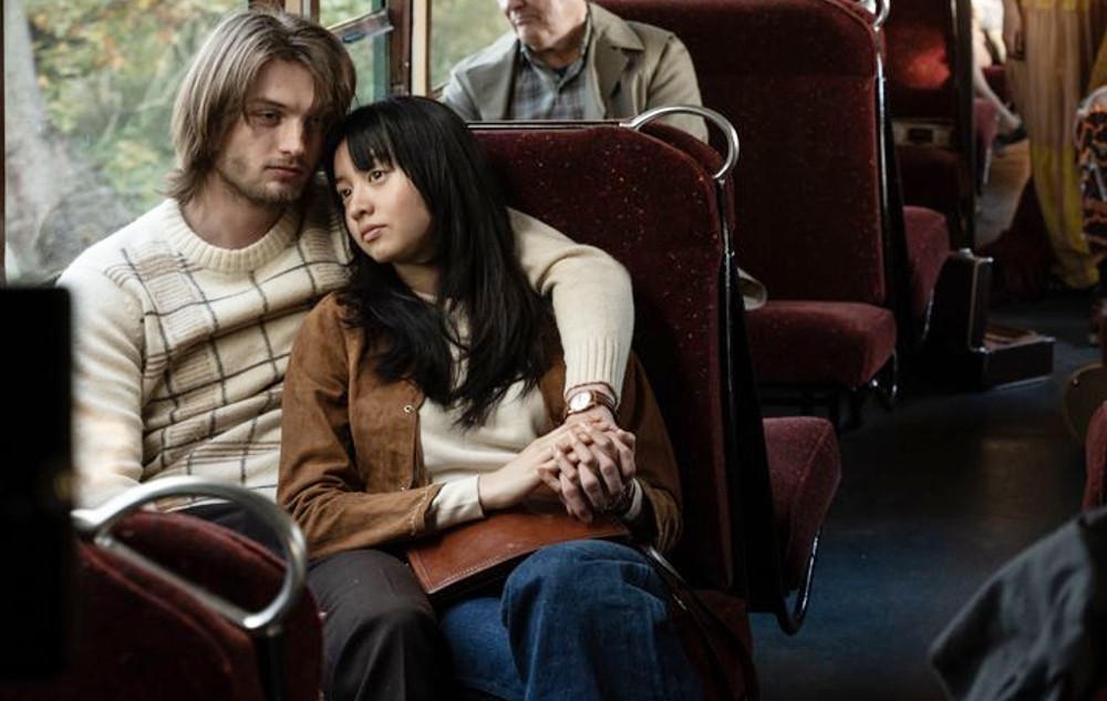 टच में एक पुरुष और एक महिला बस में बैठे हैं।