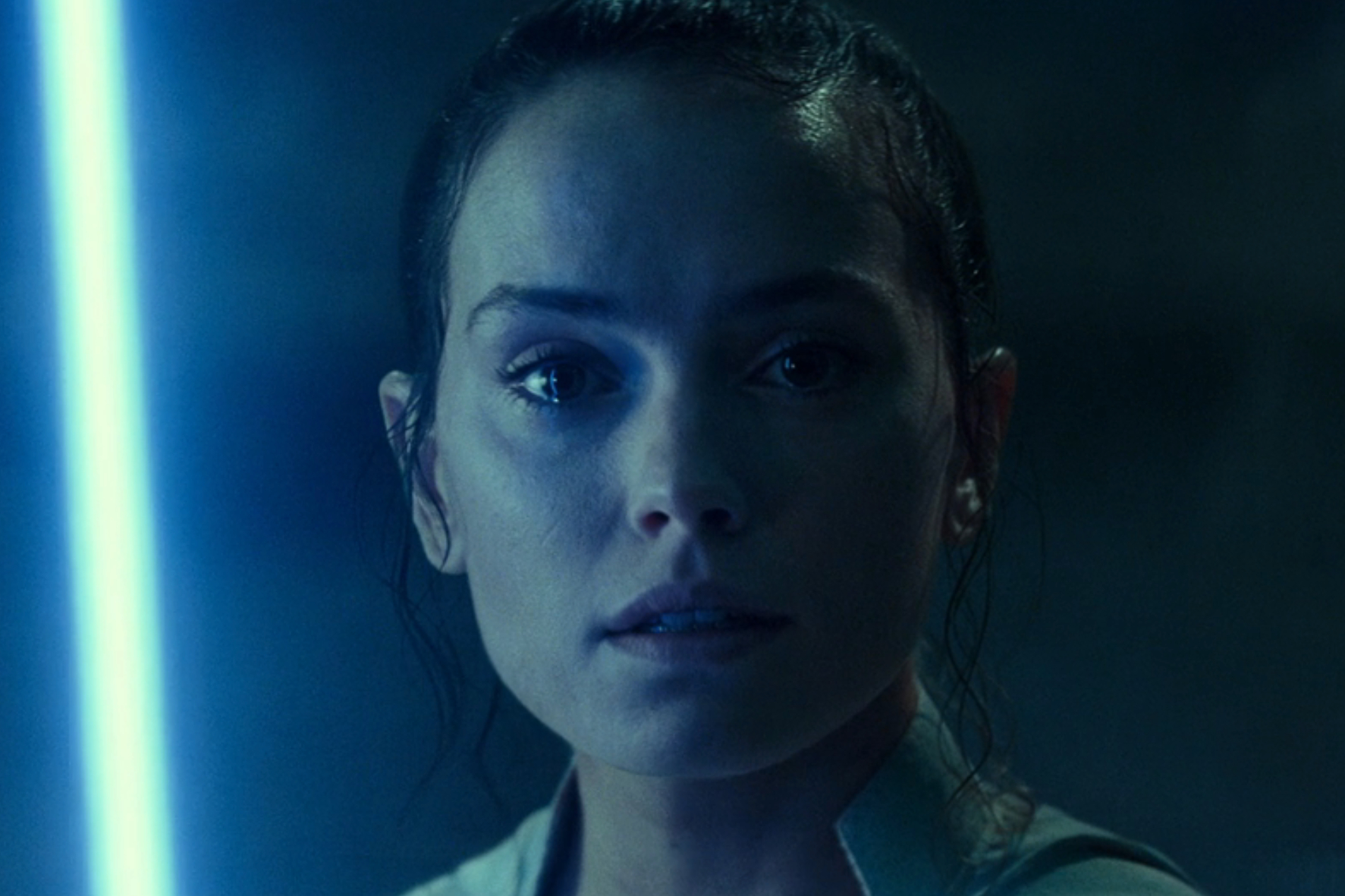 Un sable de luz azul ilumina la cara de Rey en Star Wars: Episodio IX - El ascenso de Skywalker.