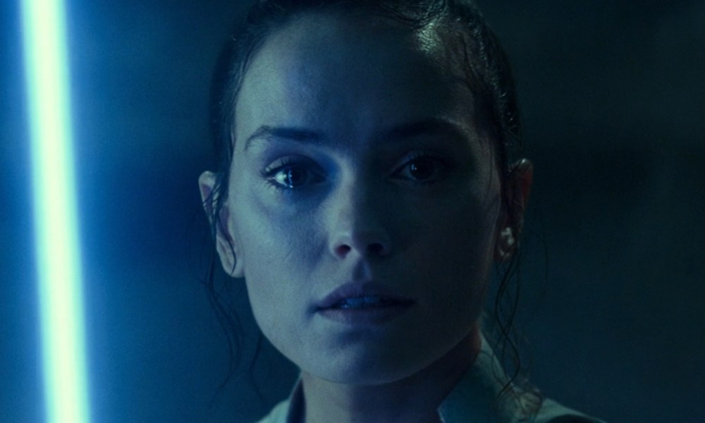 A blue lightsaber lights up Rey's face in Star Wars: Episode IX - The Rise of Skywalker.