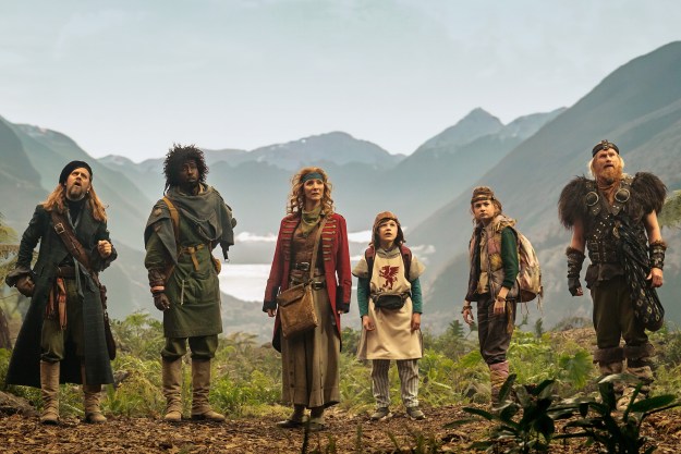 A crew of time travelers stand in front of mountains in Time Bandits.