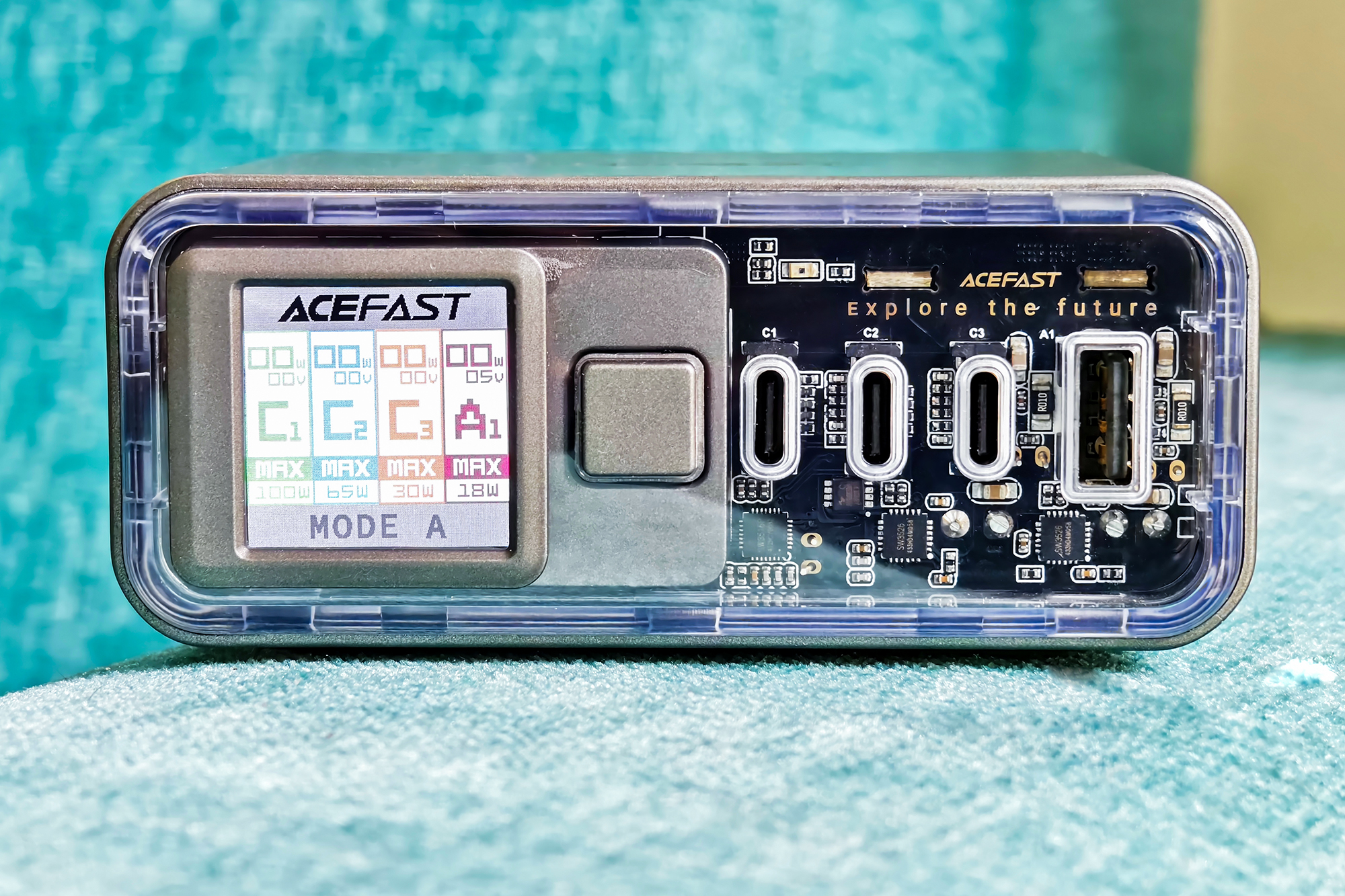 Acefast Z4 218W fast charger with display and transparent front panel kept on a blue fabric surface.