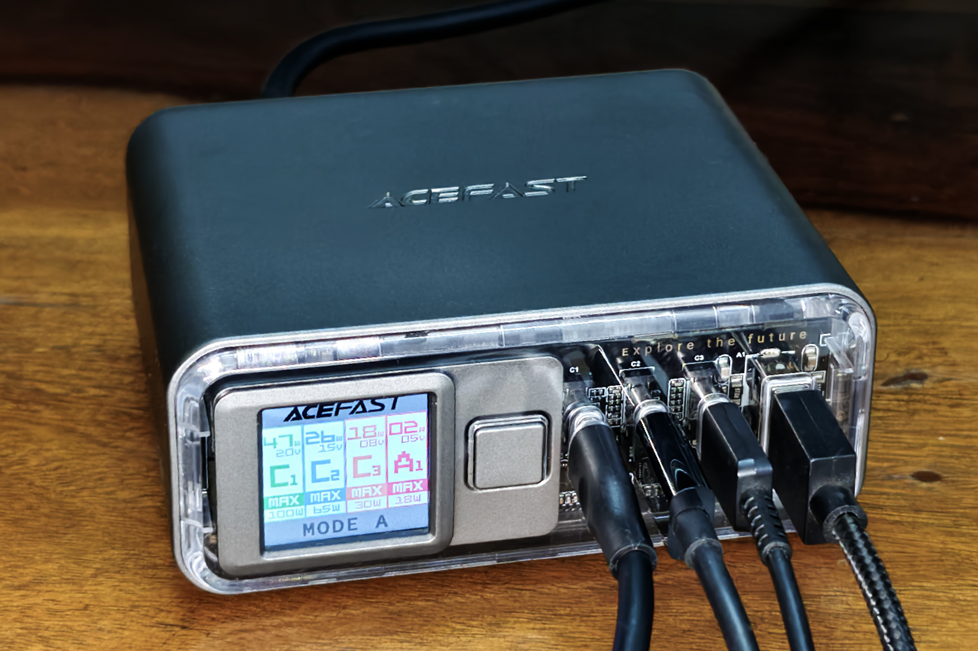 Acefast Z4 218W fast charger with display and transparent front panel kept on a wooden surface.