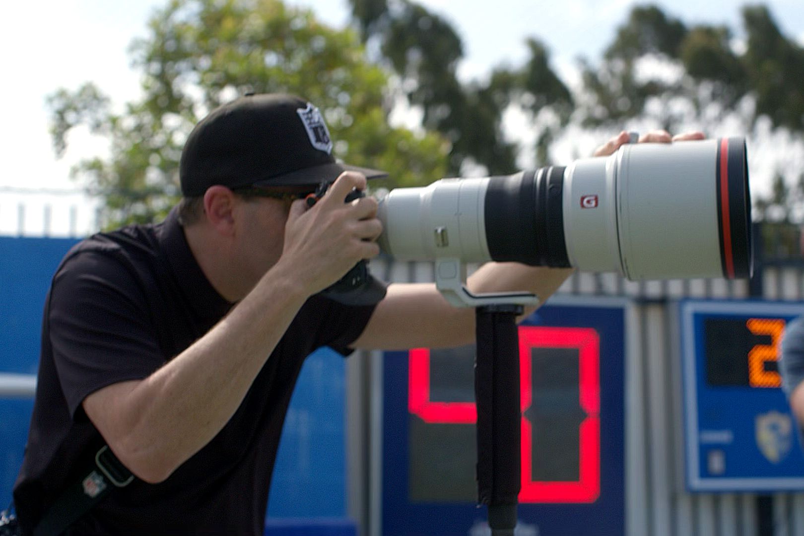 Fotógrafo oficial da NFL usando câmera e lente Sony.