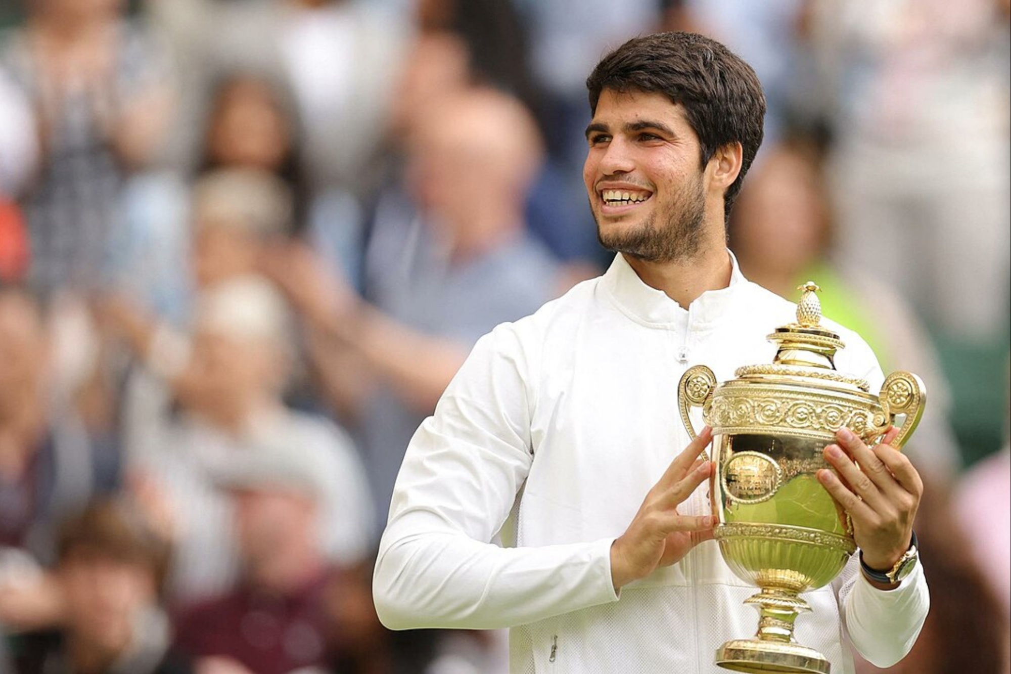 Carlos Alcaraz hält in Wimbledon eine Trophäe in der Hand.