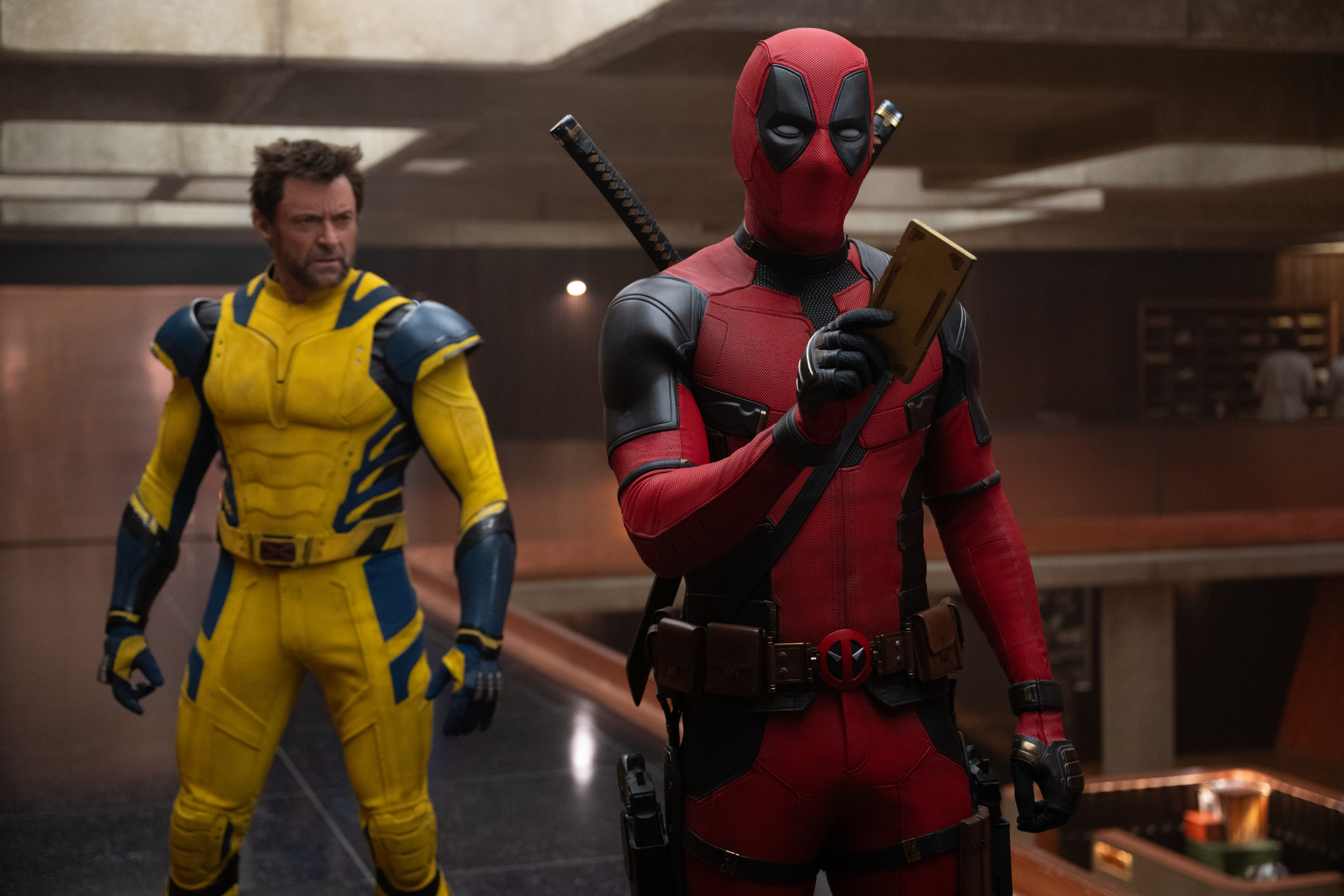 Deadpool stands in front of Wolverine in the TVA headquarters in Deadpool & Wolverine.