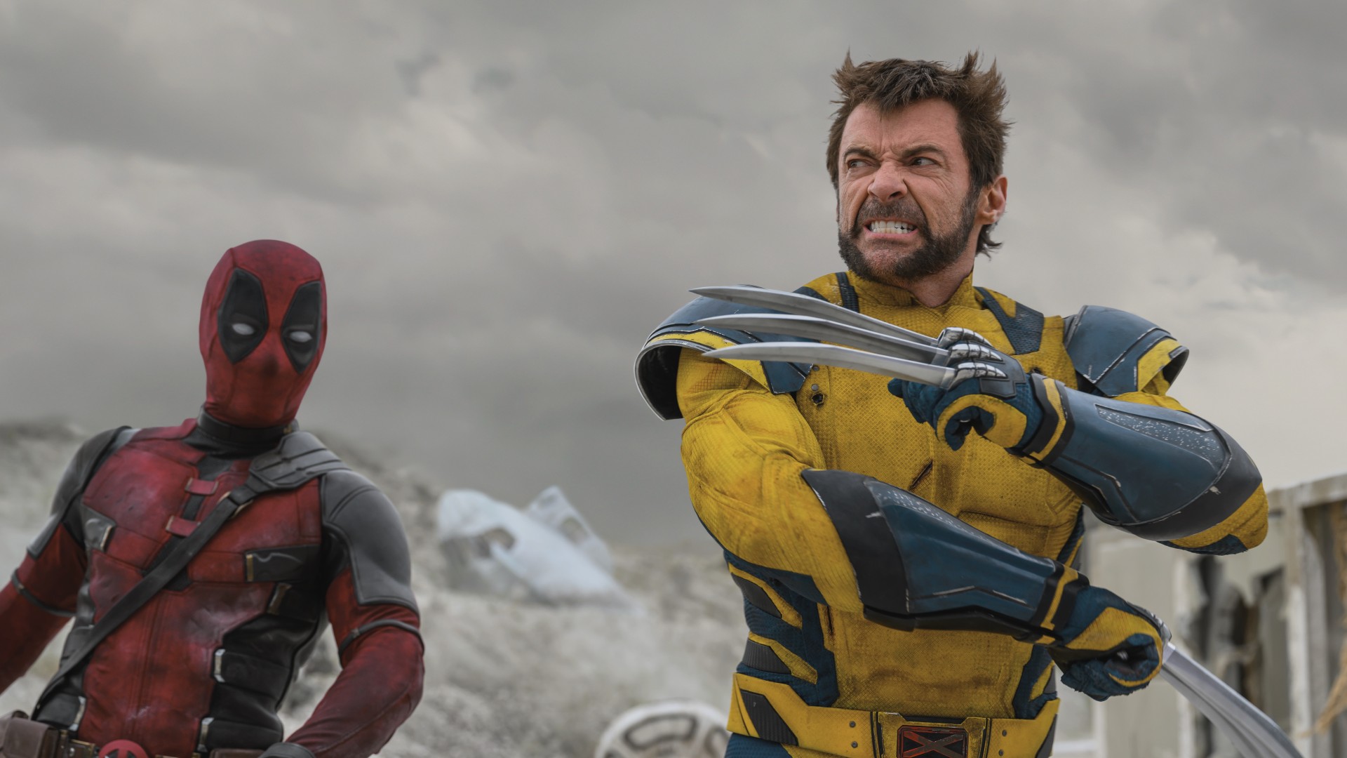 Un Ryan Reynolds enmascarado observa cómo Hugh Jackman posa con sus garras en una imagen de la película "Deadpool y Wolverine".