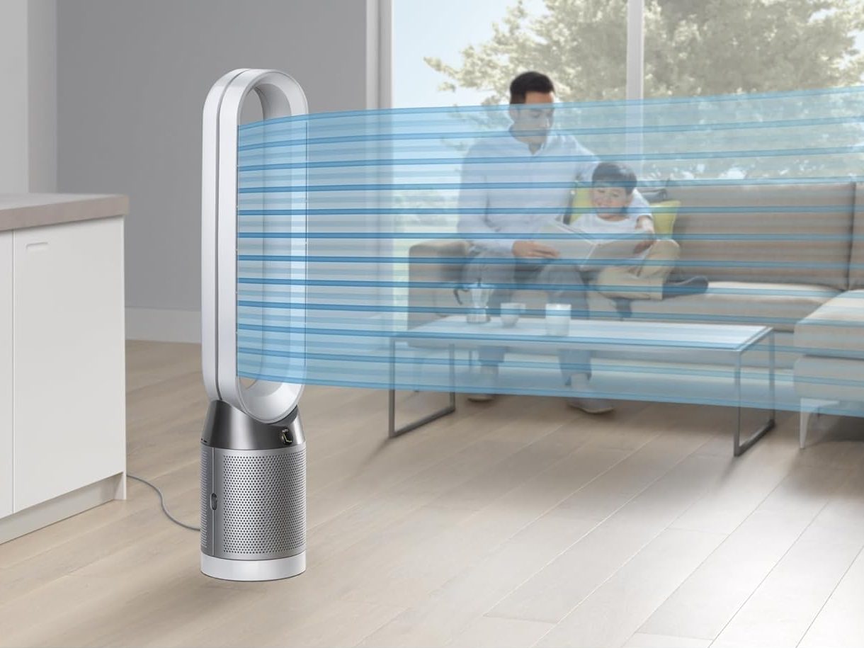 A father and son read together while being cooled by purified air from the Dyson Purifier Cool TP4B.