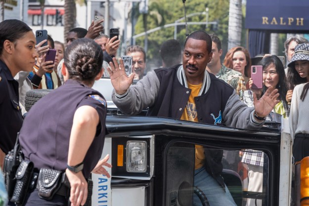 Eddie Murphy holds his hands up in front of a police officer in Beverly Hills Cop: Axel F.
