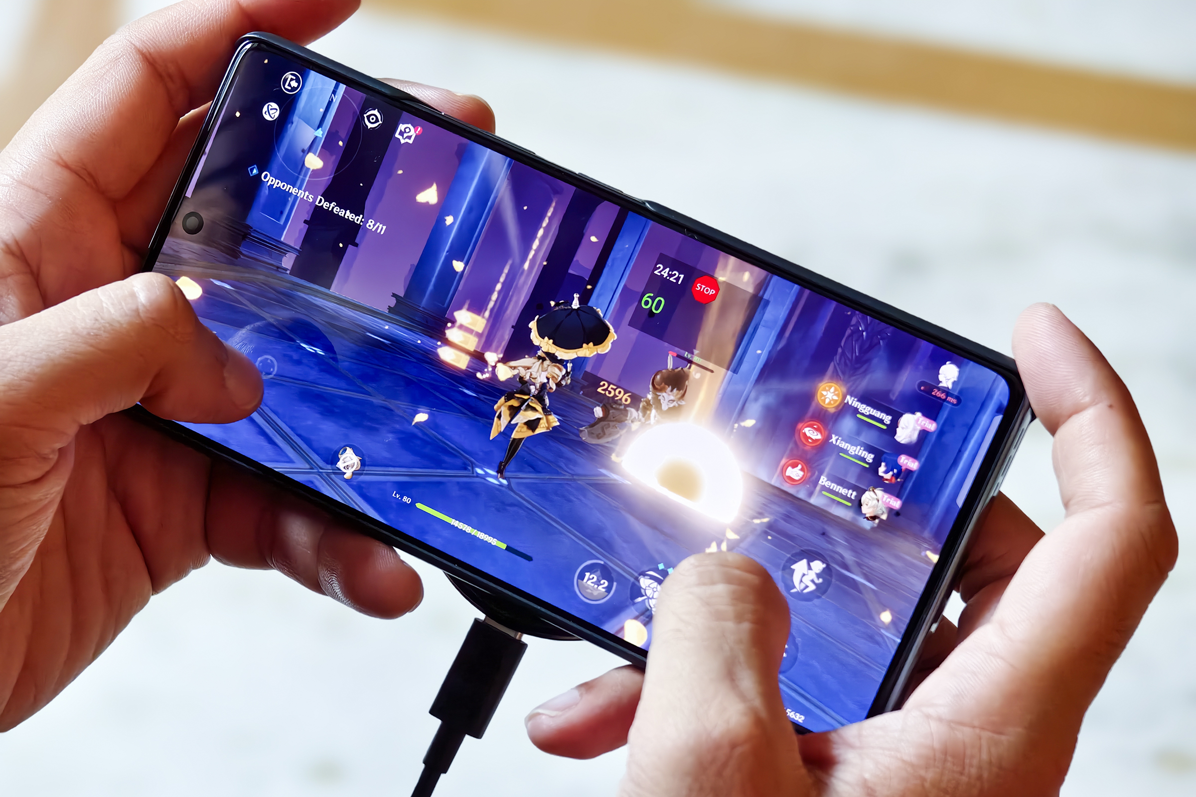 Écran AMOLED avec Genshin Impact fonctionnant à 60 ips sur le téléphone de jeu Infinix GT 20 Pro tenu en main.