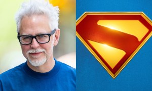 James Gunn smiles for a photo on the left with a Superman logo on the right.