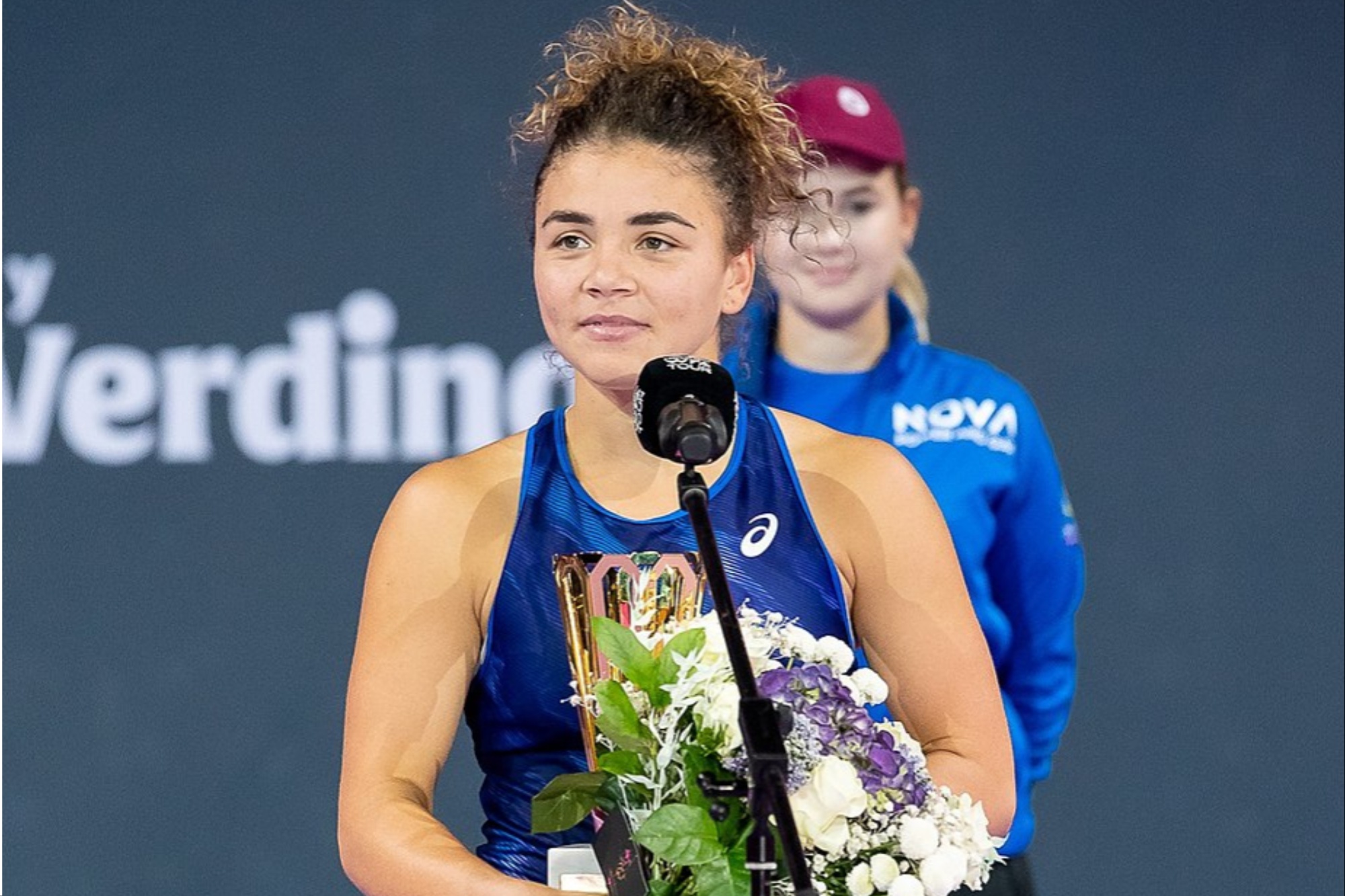 Una mujer posa para una foto con un trofeo.