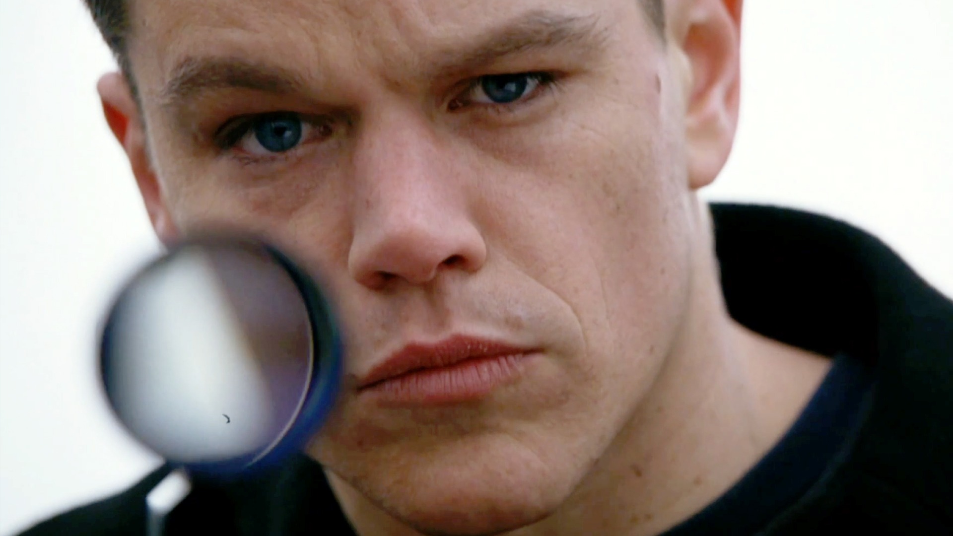 Matt Damon como Jason Bourne mirando directamente a la cámara mientras sostiene un rifle de francotirador en The Bourne Supremacy.