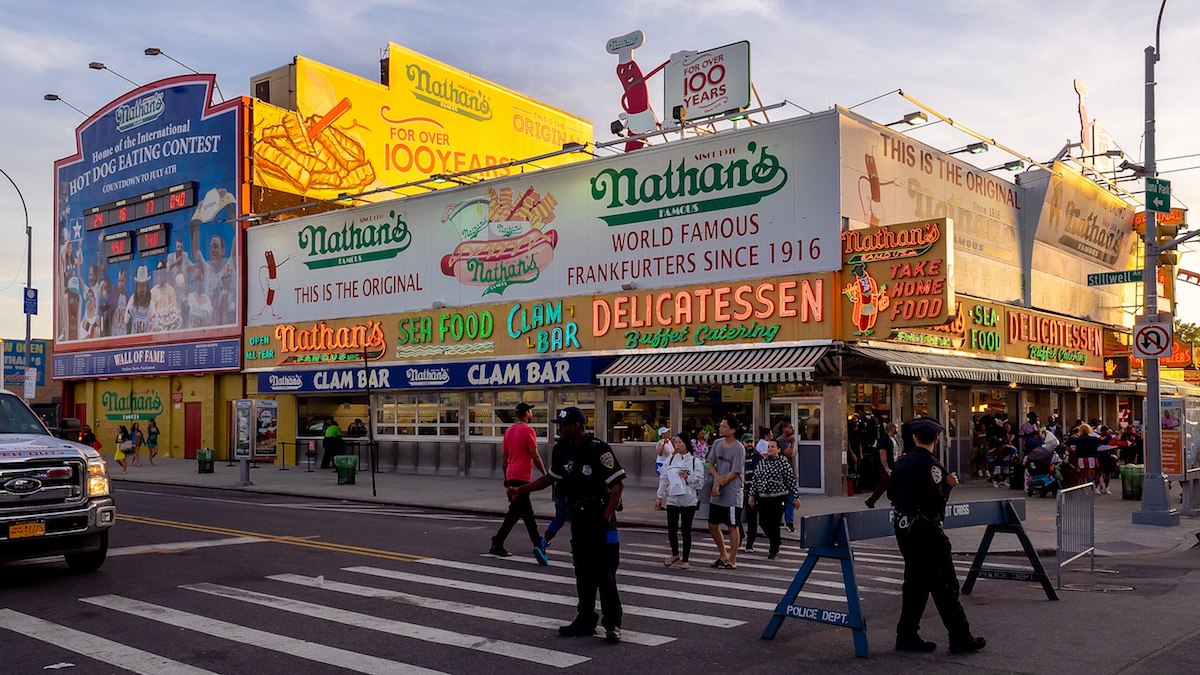 People walk on the streets outside of Nathan's in Coney Island.