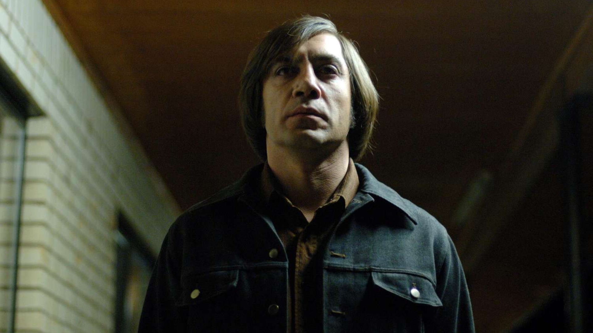 Javier Bardem como o ameaçador assassino Anton Chigurh em No Country for Old Men.