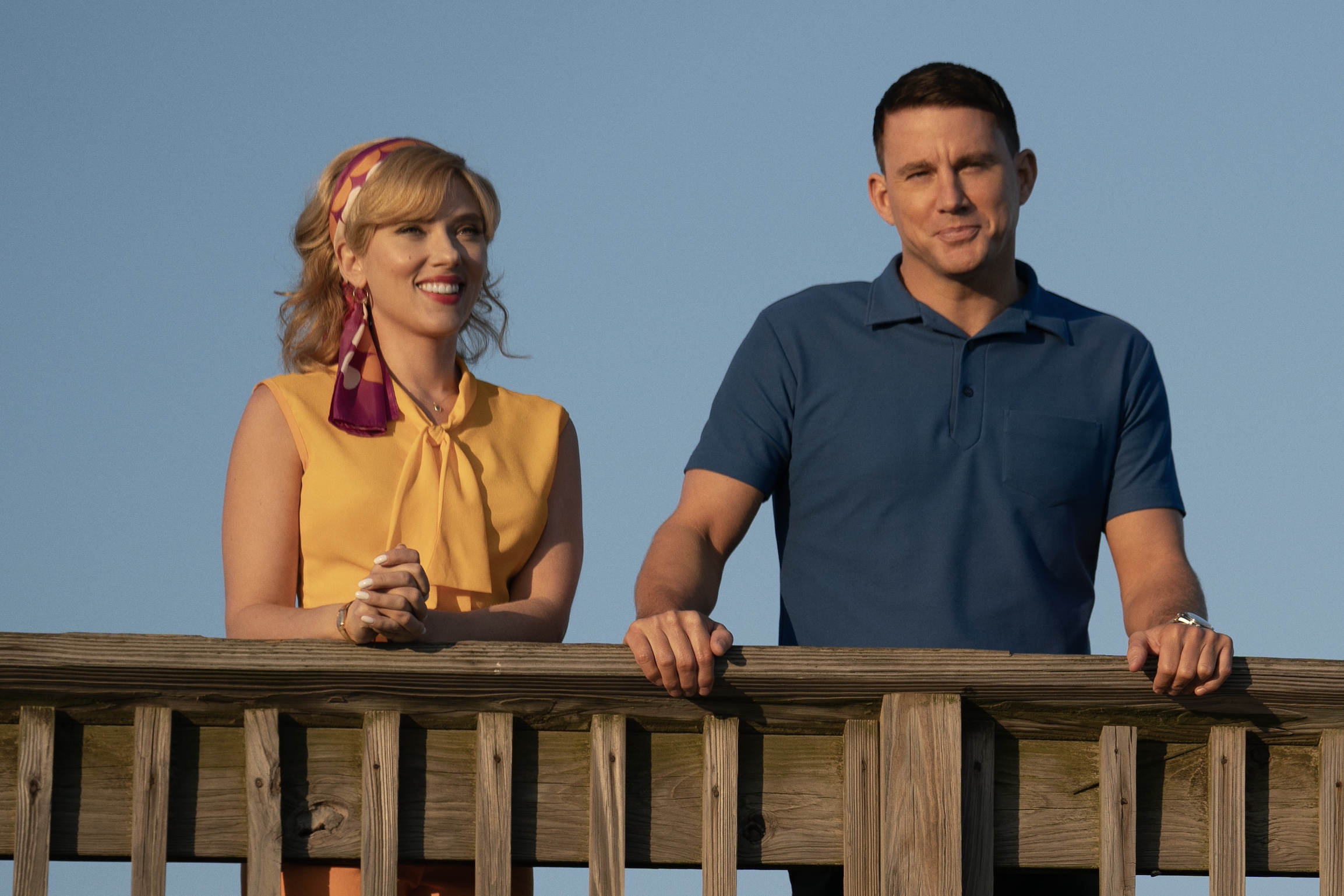 Scarlett Johansson e Channing Tatum se apoiam na grade do cais em Fly Me to the Moon.