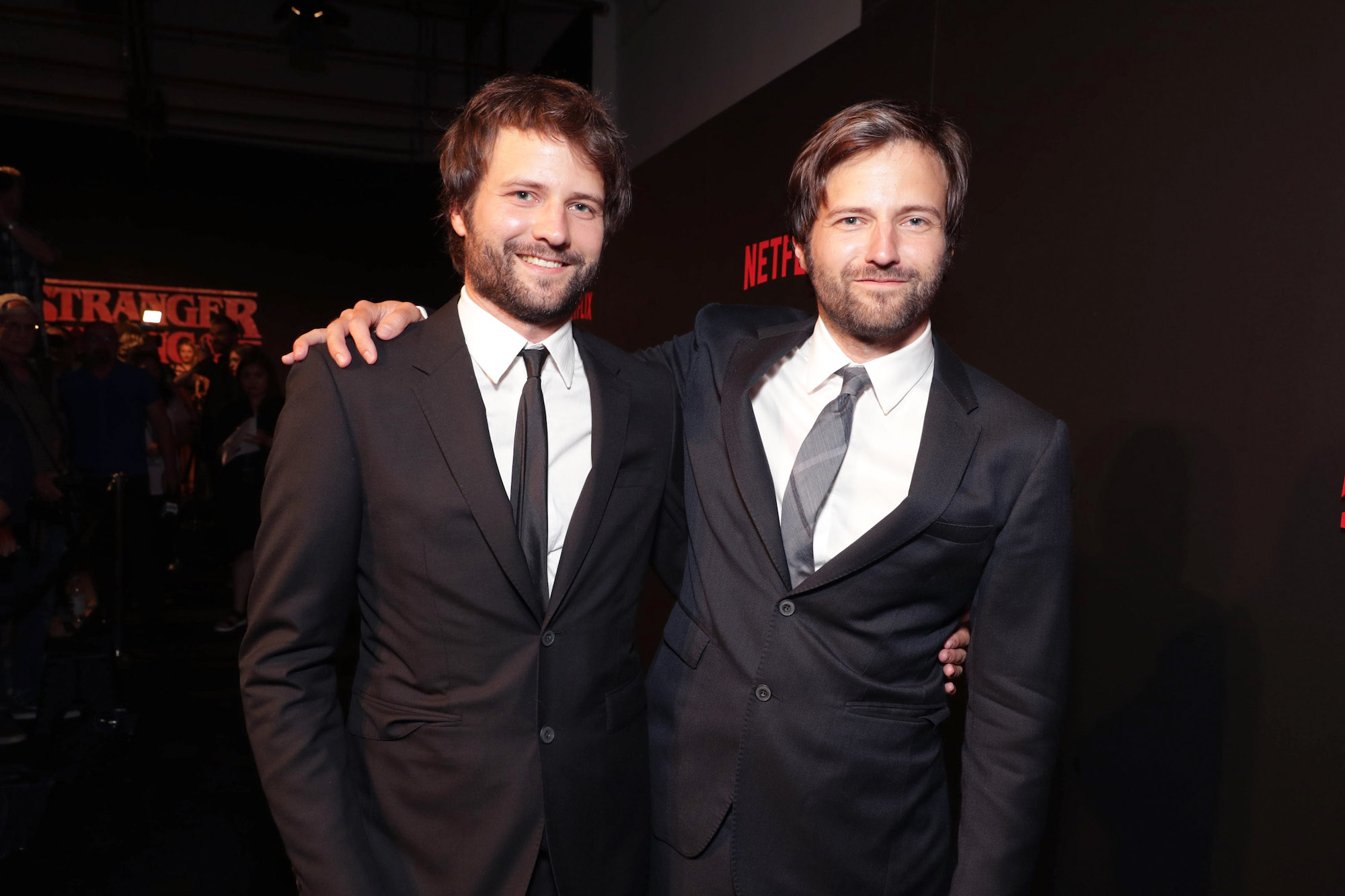 Two men in suits pose for a picture.