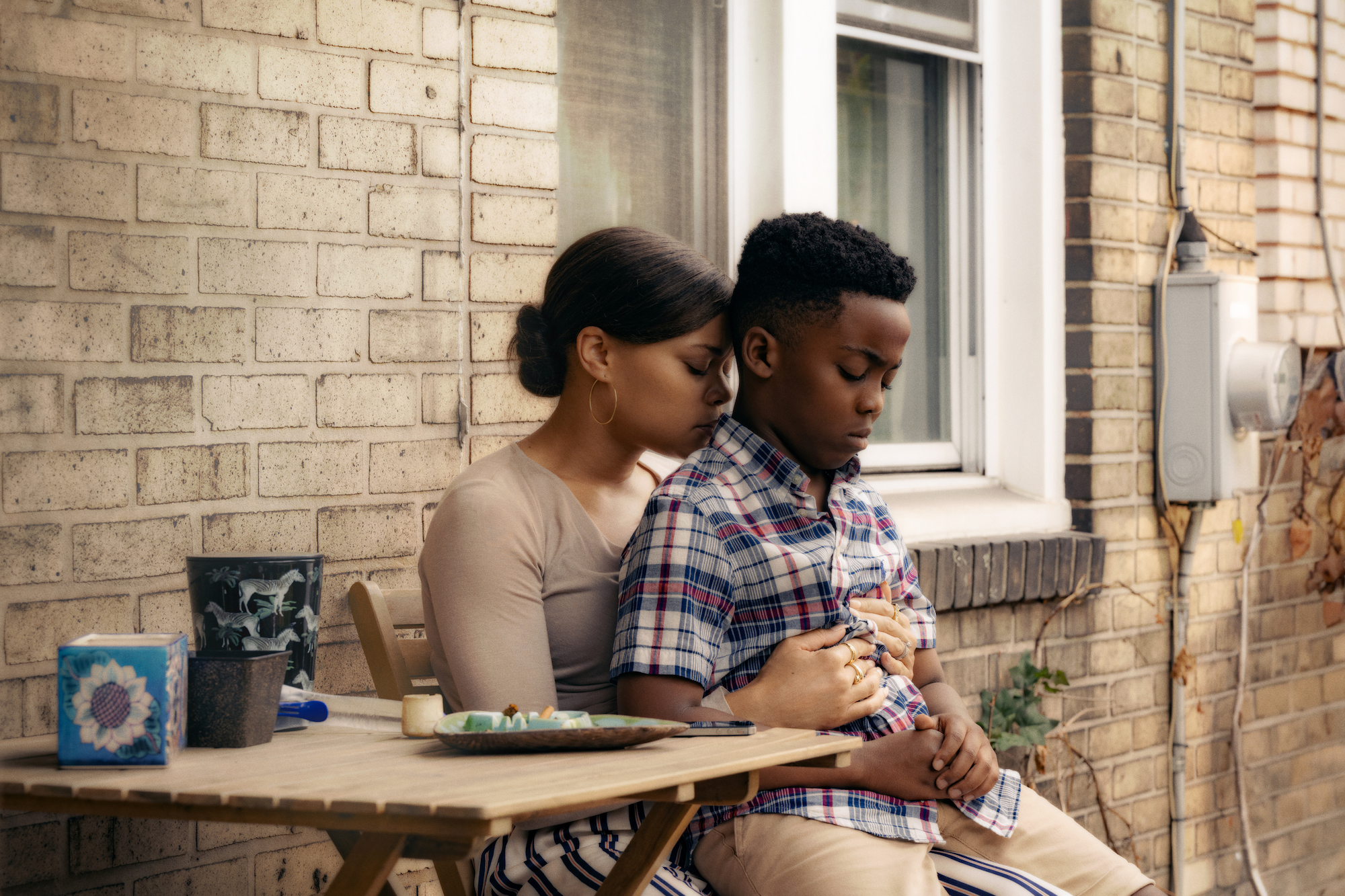 A woman sits down and holds her son.