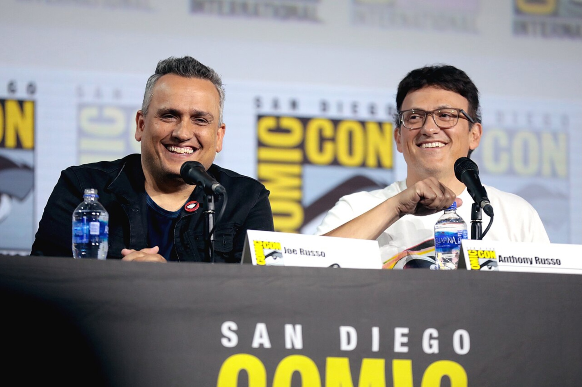 The Russo Brothers pose at a table at Comic-Con.