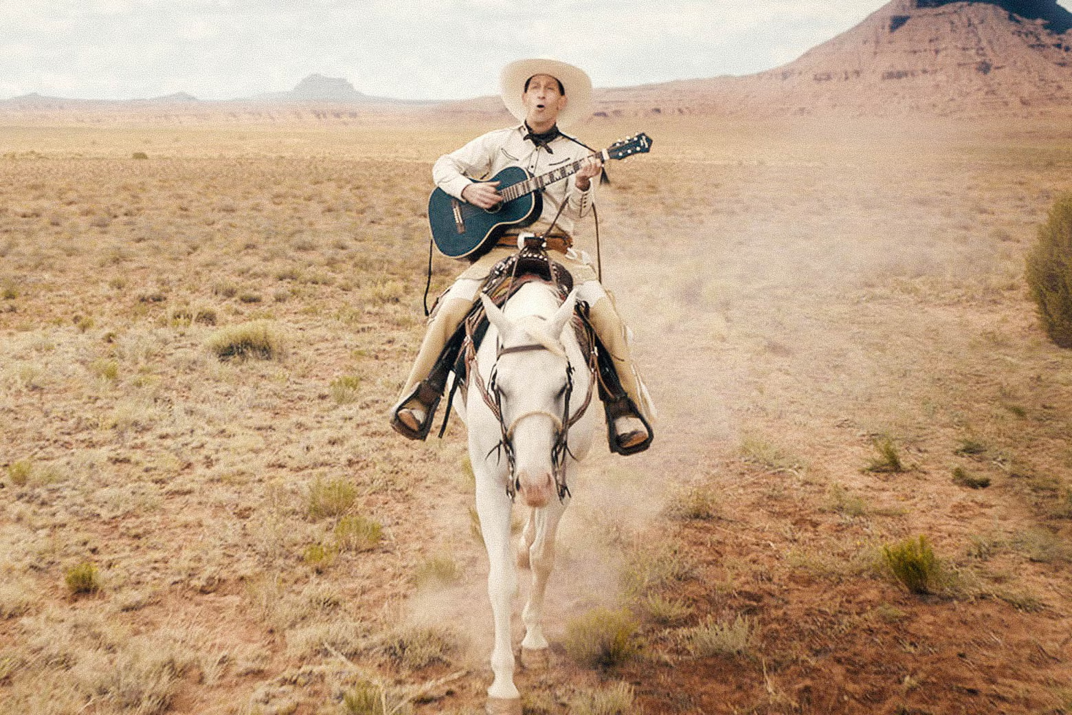 Tim Blake Nelson plays a guitar while riding a horse in The Ballad of Buster Scruggs.