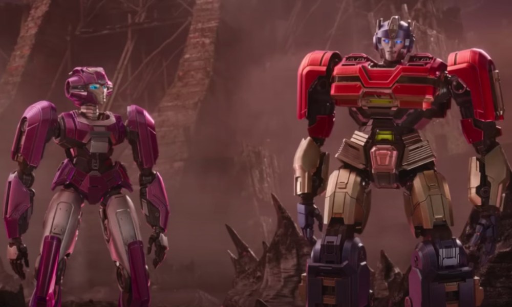 Two robots stand next to each other in Transformers One.