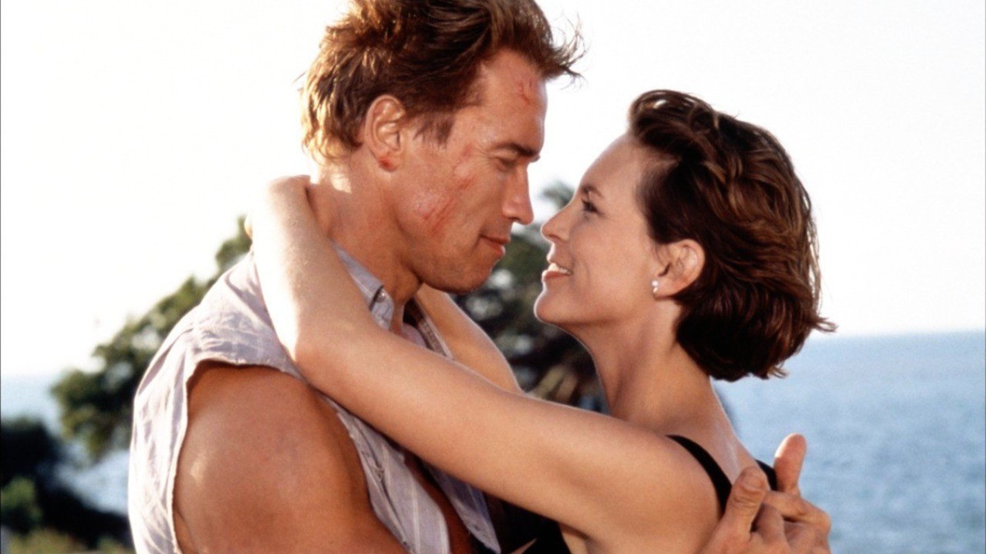 Arnold Schwarzenegger y Jamie Lee Curtis se abrazan en un fotograma de la película Mentiras verdaderas