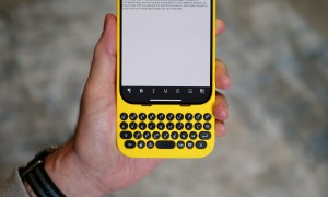 A person holding the iPhone 15 Pro Max inside the Clicks Keyboard case.