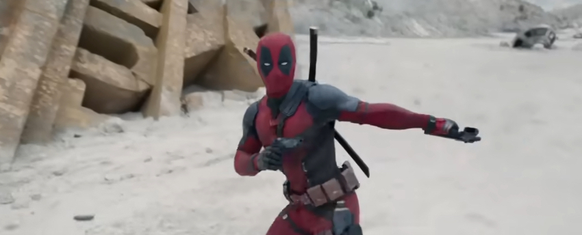 Deadpool brandit ses pistolets devant une enseigne détruite de la 20th Century Fox dans Deadpool & Wolverine