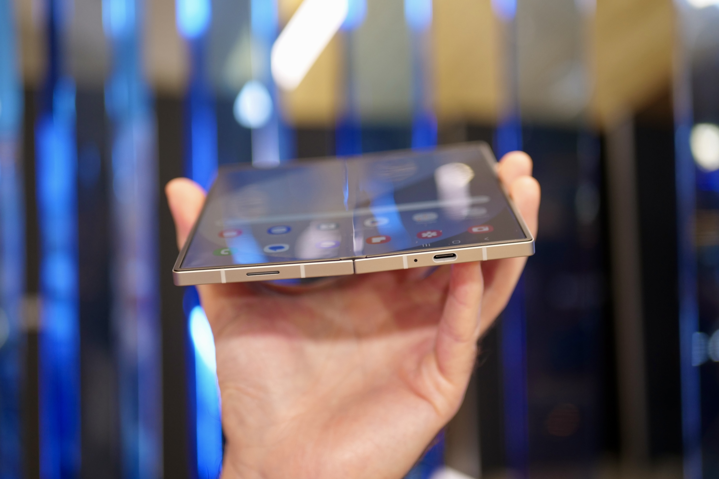 A person holding the open Samsung Galaxy Z Fold6, showing the bottom of the device.