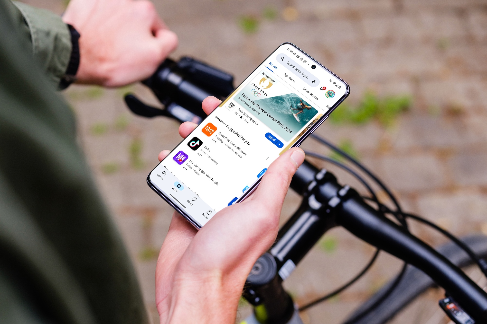 Eine Person hält ein Android-Telefon in der Hand, während sie mit dem Fahrrad unterwegs ist. Auf dem Display wird der Google Play Store angezeigt.