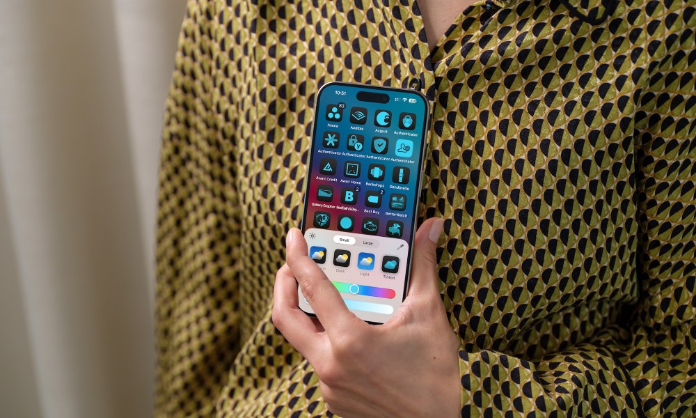 Person holding an iPhone showing new home screen customization tools on iOS 18.