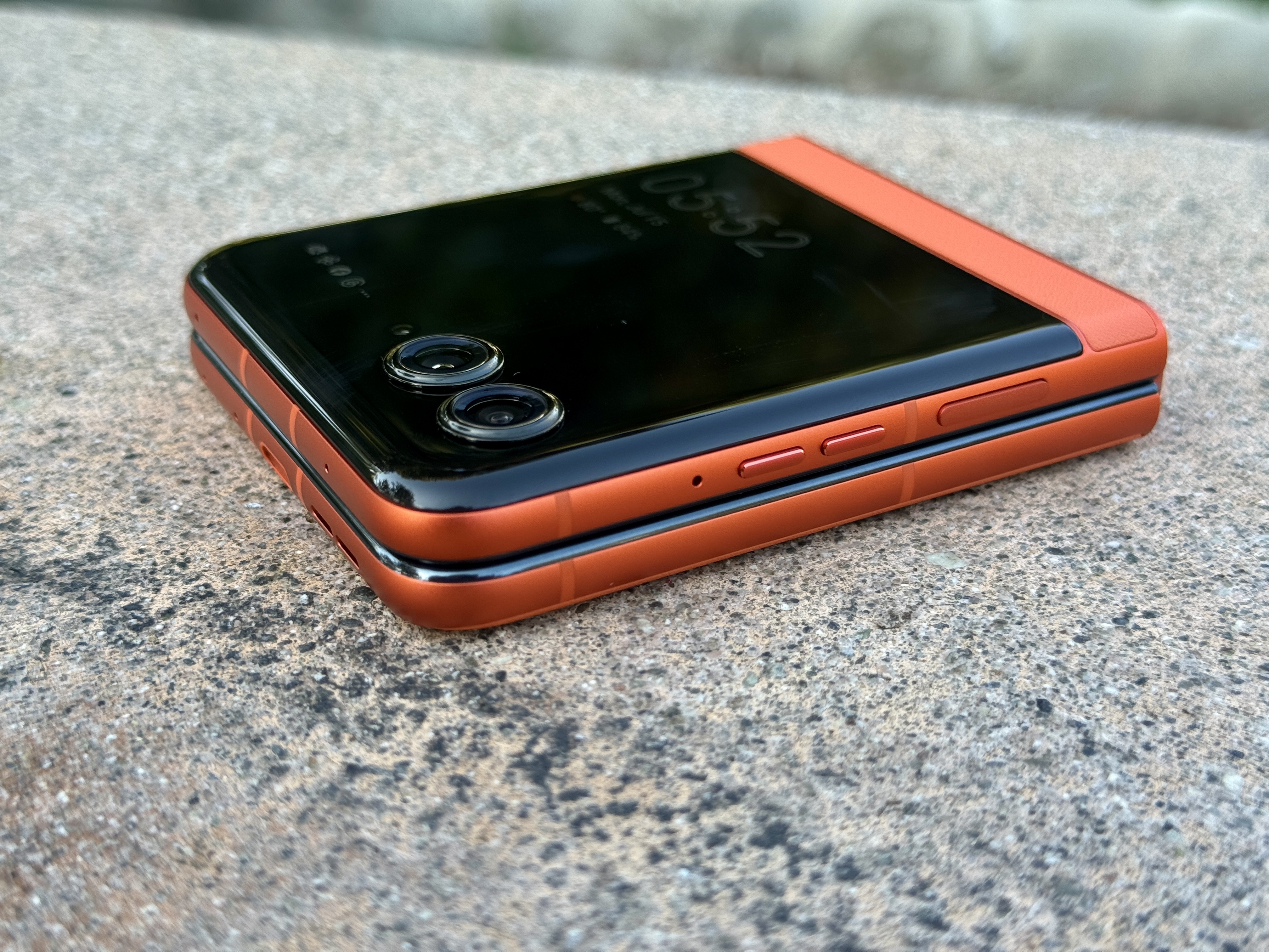 Motorola Razr 2024 en Spritz Orange, vue inclinée à plat fermée.