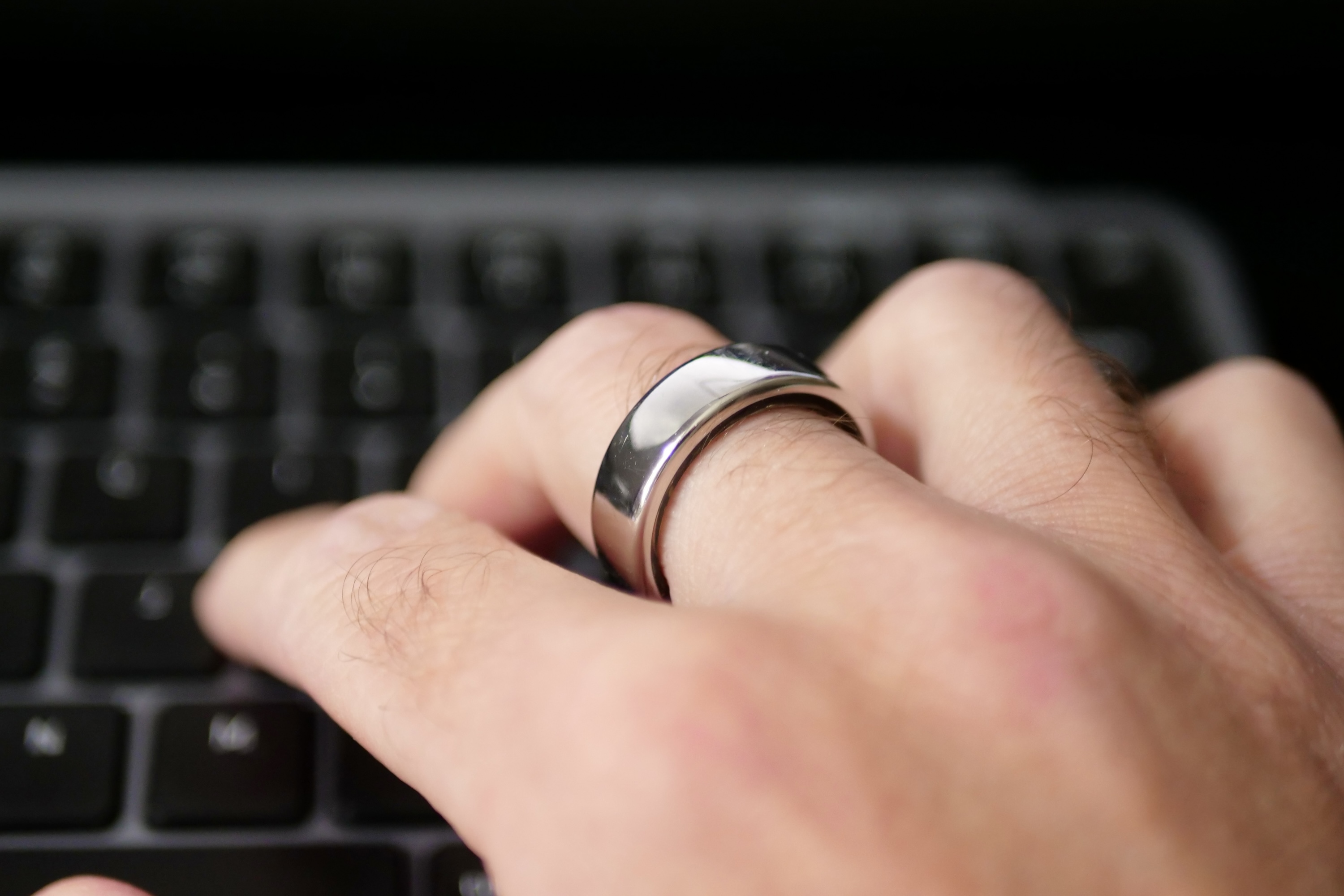 A person typing wearing the Oura Ring.