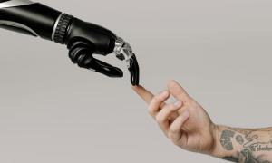 robot and human hands touching fingertips