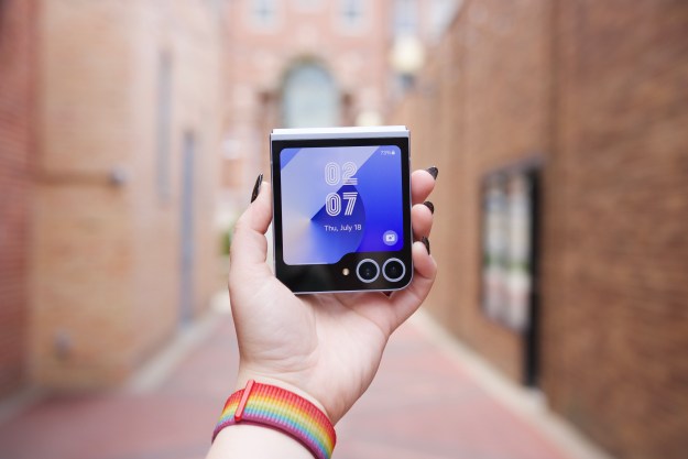 Someone holding the Samsung Galaxy Z Flip 6, showing the cover screen turned on.