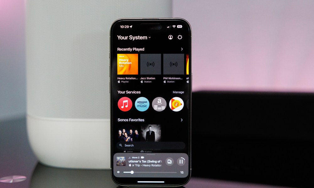 Sonos app on iPhone in front of a Sonos Move 2 speaker.