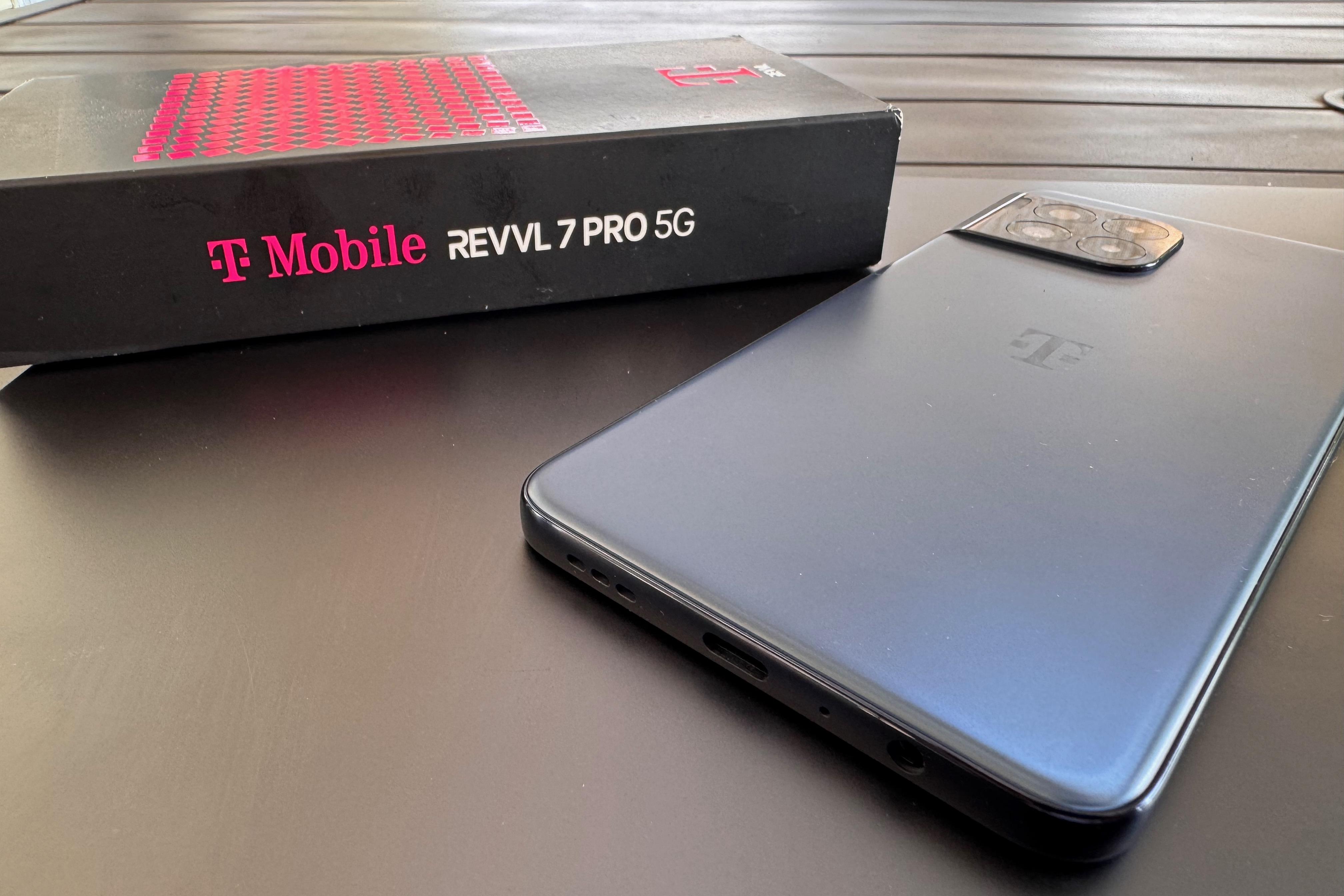 T-Mobile REVVL 7 PRO 5G próximo à caixa.