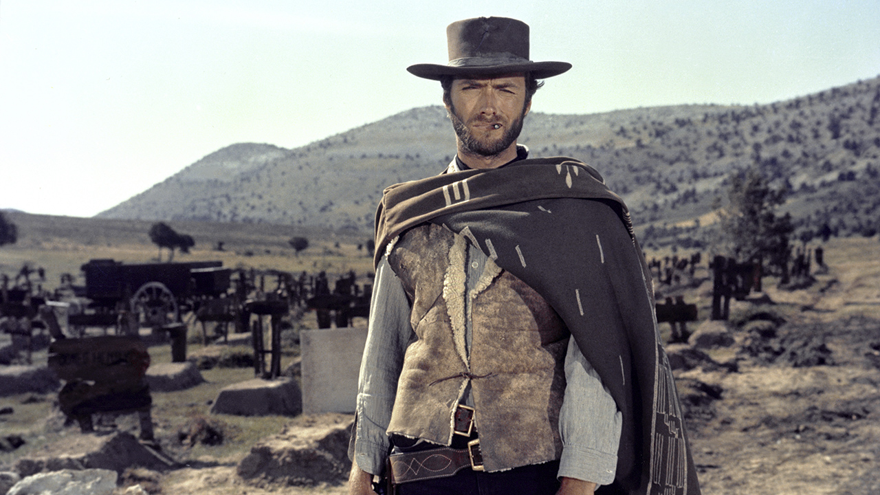 Clint Eastwood parado no deserto usando um chapéu e olhando diretamente para a câmera em O bom, o mau e o feio.