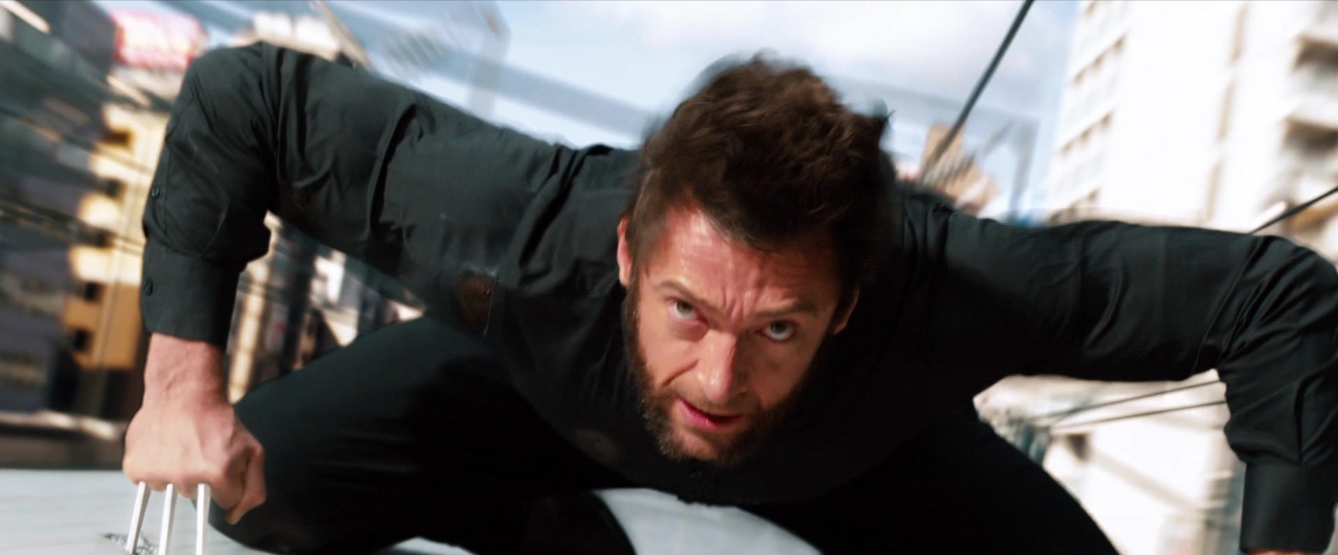 Logan (Hugh Jackman) s'accroche au sommet d'un train à grande vitesse dans The Wolverine.