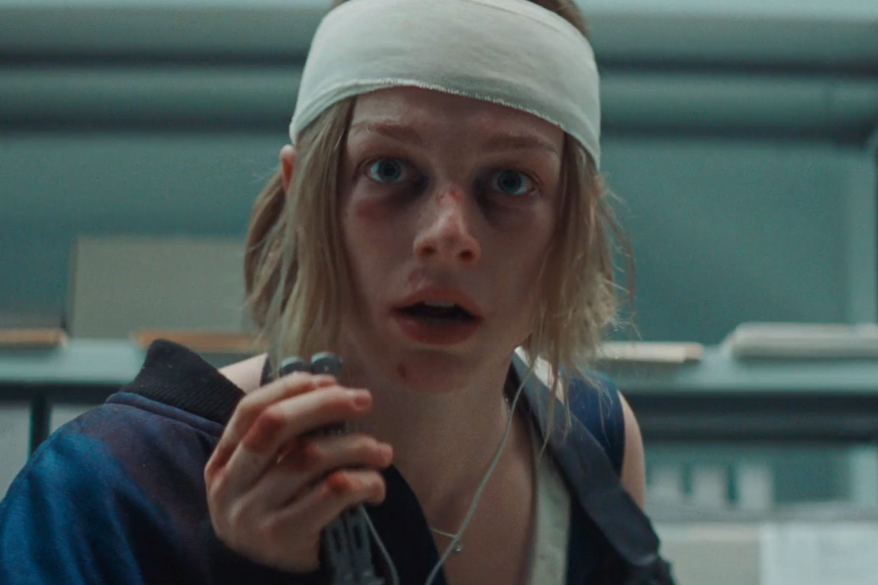 A bandaged Hunter Schafer holds a butterfly knife in Cuckoo.